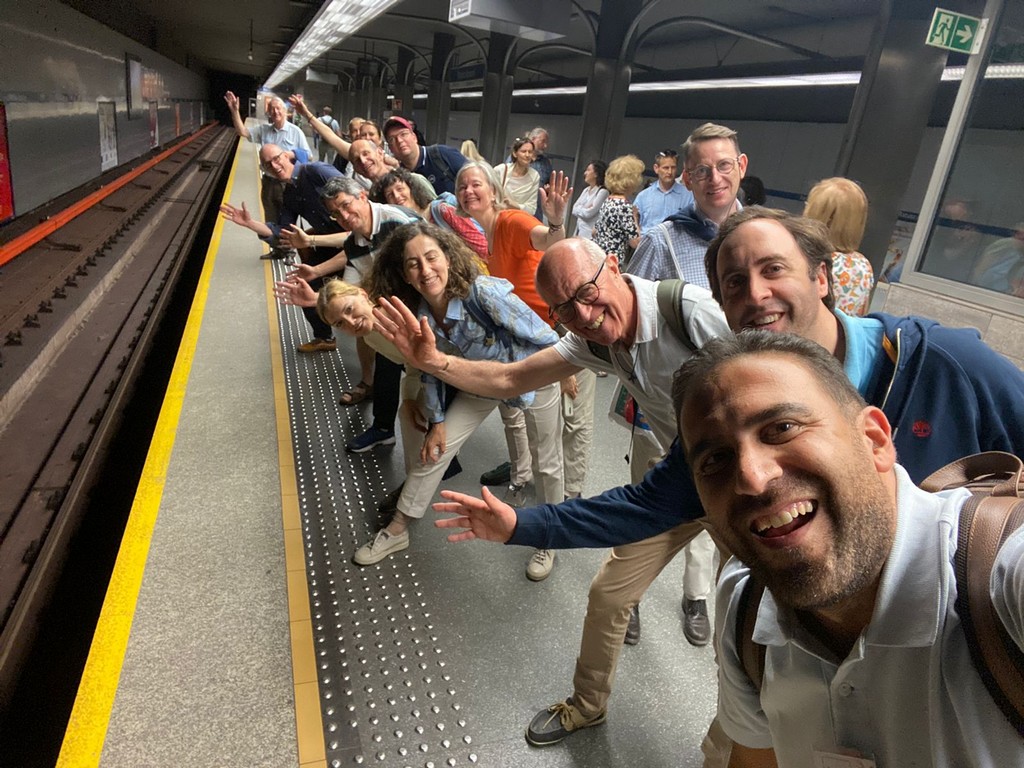 Zdjęcie - uczestnicy spotkania stoją na peroie metra i machają do zdjęcia.